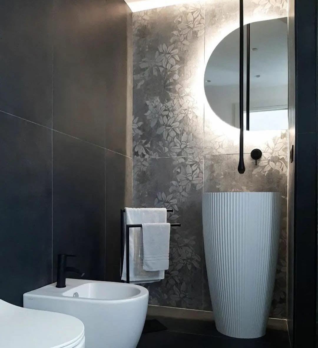 Bagno realizzato con rivestimenti scuri e parete decorativa